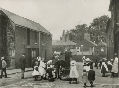 Menschenmenge von Kindern versammelt sich um eine Straßenorgel von English Photographer